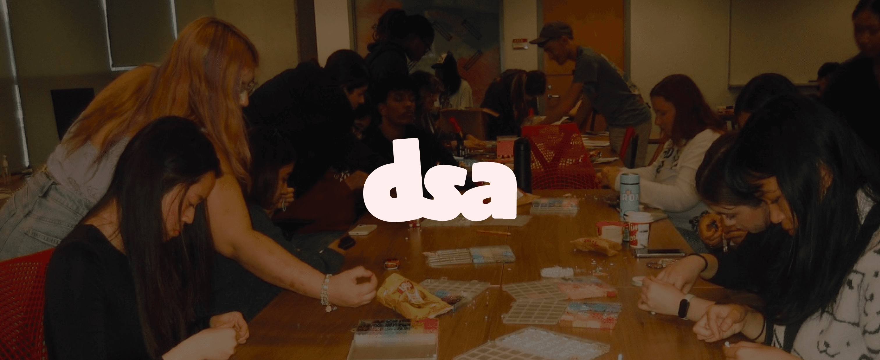 DSA wordmark on a tote bag, laptop, mug, and phone